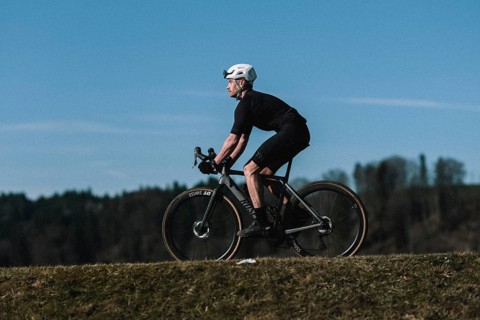 Road bike rider in spring near Halblech in the Allgäu in front of a picturesque backdrop of the