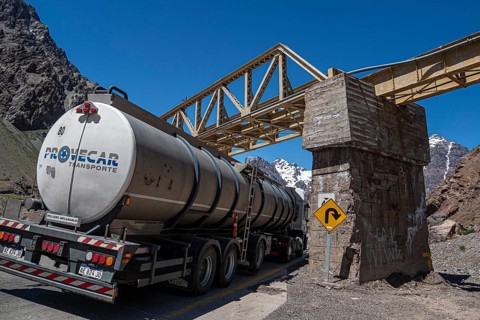 Truck driving under a bridge, mountain pass Los Caracoles, The Snails, road connecting Chile and
