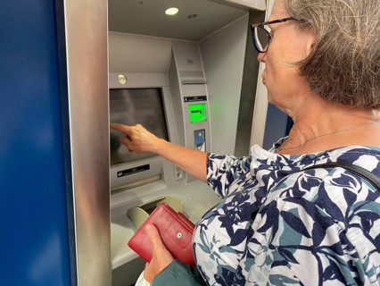 Elderly woman at EC cash machine, BW-Bank, Baden-Württembergische Bank, taps on display, terminal,