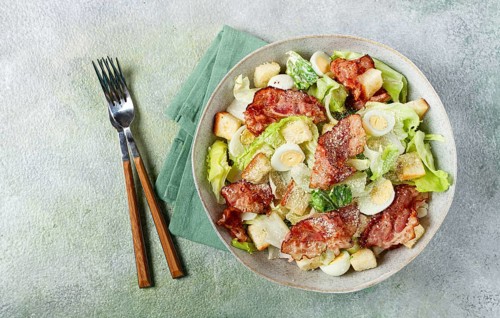 Caesar salad with fried bacon, quail eggs, homemade, no people