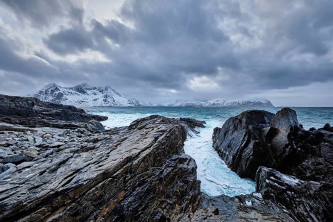 Waves of Norwegian sea crushing at rocky coast in fjord. Vikten, Lofoten islands, Norway, Europe