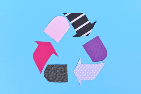 Textile recycling arrow symbol made from old clothing pieces