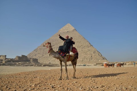 Camel owners on a camel in front of the Pyramid of Chephren, Giza, Egypt, Africa