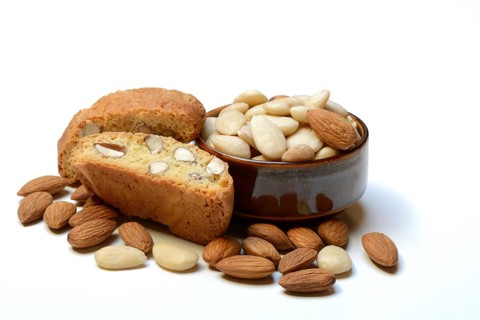 Cantucci and almonds in small bowls (Prunus dulcis)