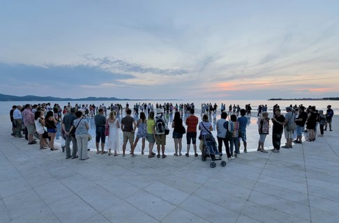 People at the Monument to the Sun, Pozdrav Suncu, by architect Nikole Bašica, at dusk, Zadar,