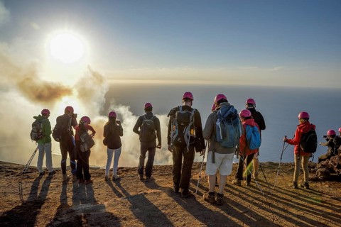 Tourists at the crater edge of the smoking layer volcano Stromboli, island Stromboli, Liparian