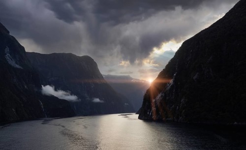 Panoramic view of scenic landscape of Milford Sound fjords in New Zealand at sunset.