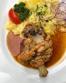 Half pork knuckle, crispy fried, potato salad, tomato, chives, parsley, onion rings, plate, food,