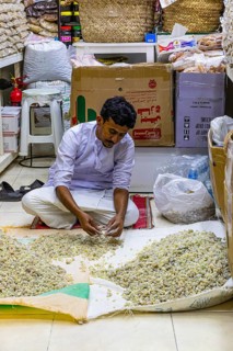 A trader sorts and misses incense in the souk of Mutrah, Muscat, Arabian Peninsula, Sultanate of