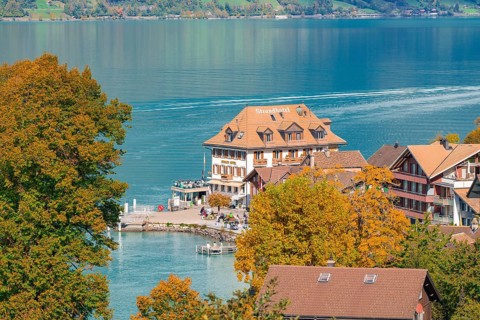 Lake hotel on the shores of a lake, surrounded by autumnal trees and a picturesque village, Lake