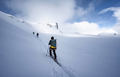Three ski tourers in a snowy mountain landscape, ascent to the Wildhorn, cloudy mood, high tour,