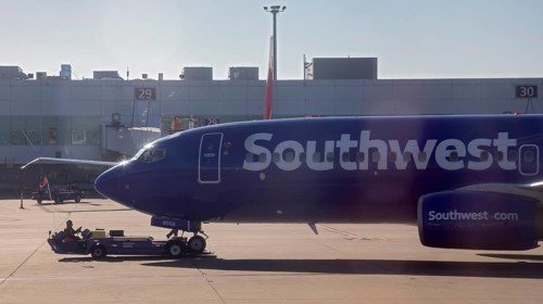 Oakland, California, A worker pushes a Southwest Airlines plane away from the gate at Oakland