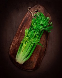 Fresh bunch of celery, top view, no people, on a dark background