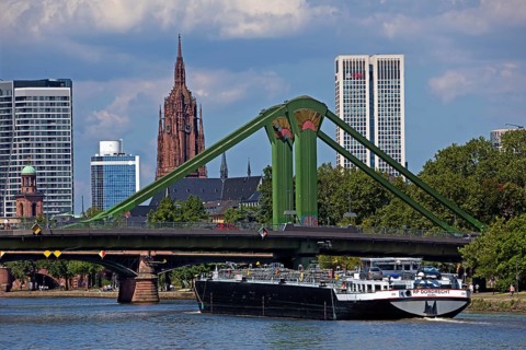 The river Main with a barge in front of the rafter bridge and the imperial cathedral of St