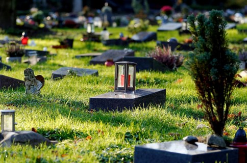 Lantern on a gravestone in a cemetery with graves of the poor against a blurred background