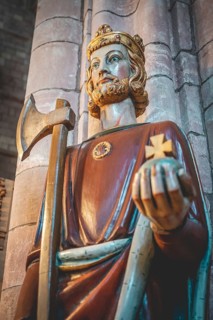 Close-up King holding rich apple, axe and a cross, indoors at St Magnus Cathedral, low angle view,