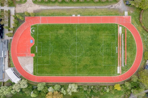 Aerial drone view of a soccer field with a red running track