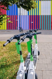 E-scooter in front of the colourful façade of the Mira shopping centre on the Nordhaide in Munich