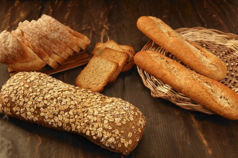 Varied bread still life over dark wood background