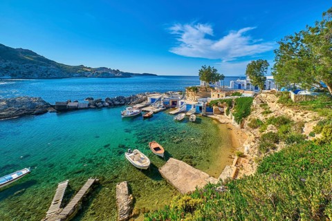 Beautiful view of secluded Mediterranean island harbour on summer day. Whitewashed houses, hills,