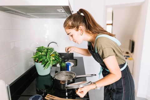 Young woman tasting soup kitchen