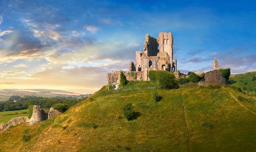 Medieval Corfe castle keep & battlements at sunrise, built in 1086 by William the Conqueror, Dorset