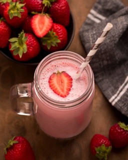 High angle strawberry milkshake with straw