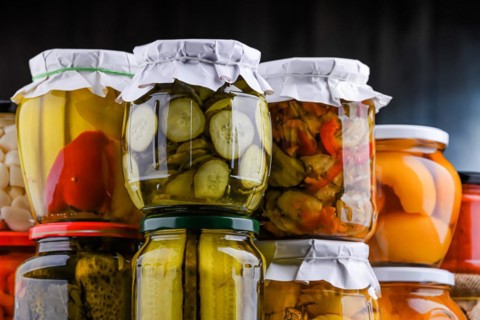 Jars with variety of marinated vegetables and fruits. Preserved food