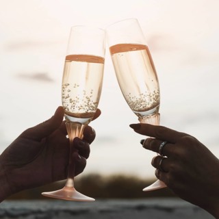 Women holding champagne glasses background sunset