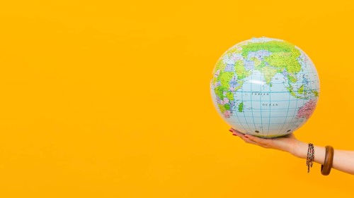 Side view hand holding globe with copy space