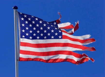 Stars and stripes, US national flag, torn, ripped, tattered, flutters flaps in the wind