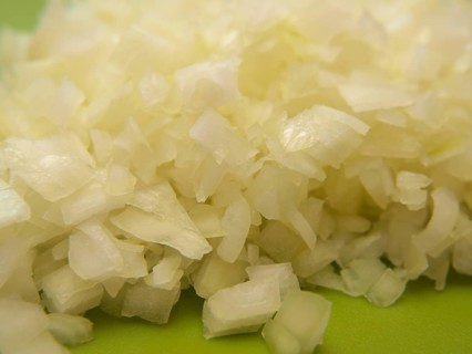 Closeup of freshly chopped onion, on chop board