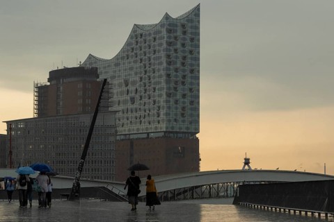 Symbolic picture weather, heavy rain in summer, thunderstorm, storm, tourists with umbrella in the