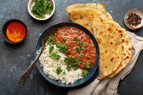 Traditional Indian Punjabi dish Dal makhani with lentils and beans in black bowl served with