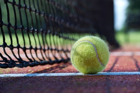 Tennis ball in the net. Ball hitting the tennis net, tennis scene with black net and yellow ball