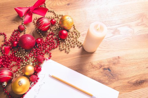 Conceptual image with a letter addressed to Santa, on a wooden table, surrounded by Christmas