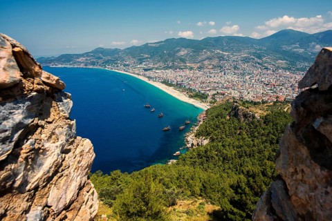 View from the castle hill over the town of Alanya with Klopatra Beach and tourist boats, Turkish