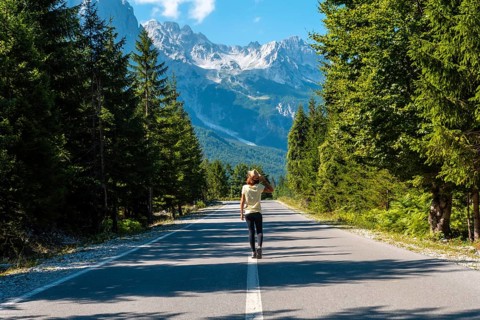 A woman walking on the road in the Valbona Valley, Theth National Park, Albanian Alps, Valbona