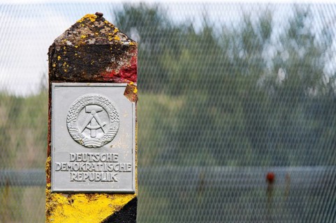 Old border post in front of a border fence on the former inner-German border