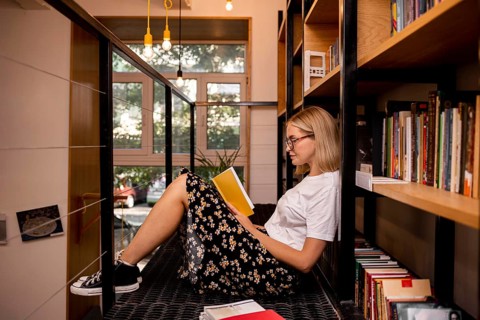 Student reading book library