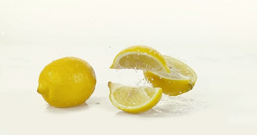 Yellow Lemons, citrus limonum, Fruits Rolling on Water and splashing against White Background