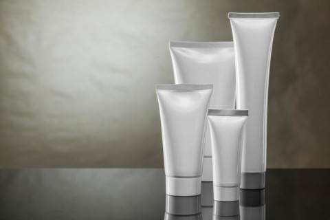 Higiene products four white plastic tubes on vintage background