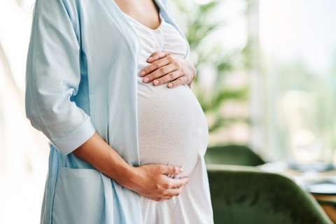Closeup of pregnant woman holding her belly. Baby expecting, motherhood care, pregnancy and safety