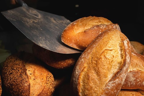 Fresh artisan bread only from the oven on a baking shovel. Close-up. Appetizing fresh and healthy