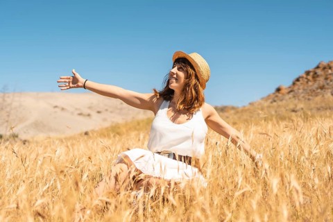 Happy woman enjoying the breeze inside a wheat field in Cabo de Gata, Spain, Europe