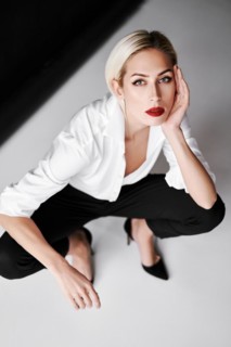 Top view portrait of daring trendy woman posing on white studio background sitting on floor.