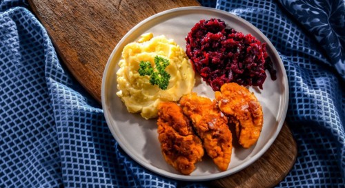 Breaded chicken cutlets served with potatoes and beetroot