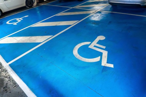 A parking lot with a blue handicap parking sign