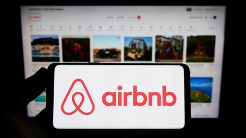 Stuttgart, Germany, 11-30-2022: Person holding smartphone with logo of US homestay marketplace