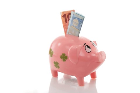 Pink piggy bank with euros on a white background